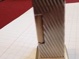 a silver lighter sitting on top of a piece of paper