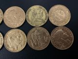 six different british coins sitting on top of a black surface