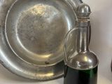 a silver plate with a bottle of olive oil next to a silver plate with a bottle of olive oil