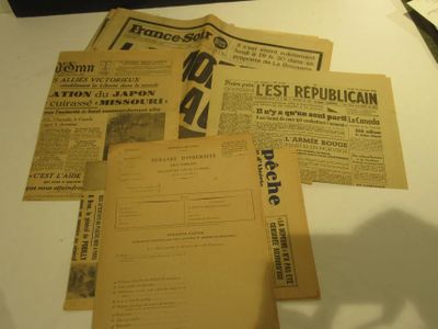 de nombreux vieux journaux posés sur une table, à côté d'une paire de ciseaux
