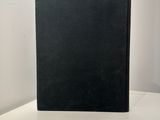 a black book sitting on top of a white table next to a white wall