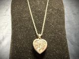 heart shaped locke necklace with a lion head on a gold chain