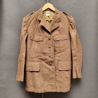 une veste marron suspendue à un cintre accroché au mur