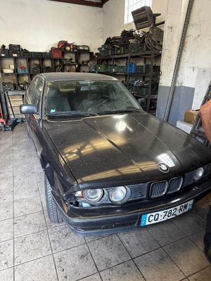 a man standing next to a black car in a garage