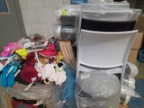a stack of clothes and a chair in a room
