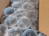 une boîte remplie de gobelets en plastique posée par terre