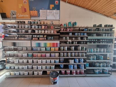 many cans of paint on the shelves in the store