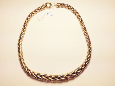 a close up of a gold necklace on a white surface