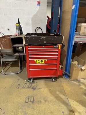 a red tool box sitting in the middle of a garage