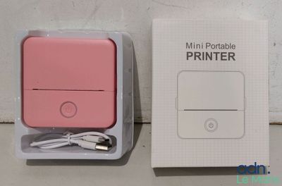 emballage d'une imprimante portable rose posée sur une boîte blanche