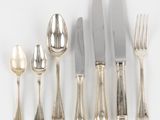 beaucoup de cuillères et de couteaux en argent sur la table