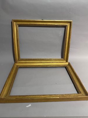 un cadre doré vide contenant un miroir, sur fond blanc