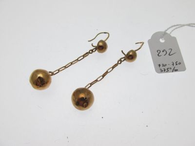 une paire de boucles d'oreilles dorées avec une étiquette attachée