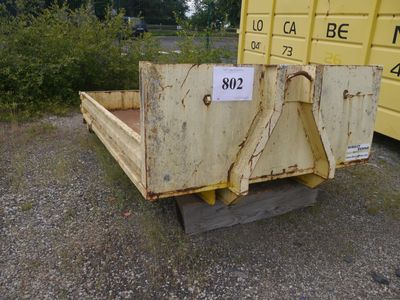 a yellow dump truck that is parked next to a yellow container
