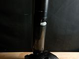 une image représentant un aspirateur posé sur une table en bois, sur fond noir