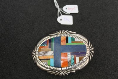 a close up of a necklace with a cross on it on a black surface