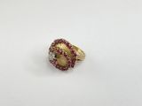 a close up of a gold ring with red and white stones