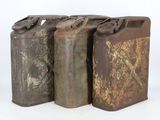 three old rusty metal cans are lined up against a white background