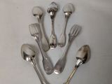 five silver spoons and two silver spoons on a white surface