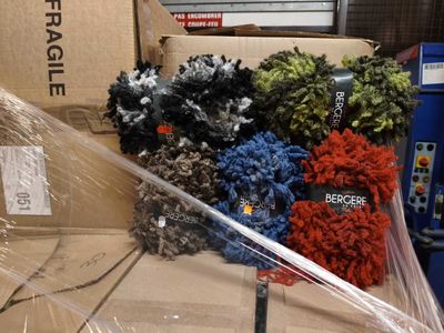 de nombreuses pelotes de laine de différentes couleurs dans une boîte en carton