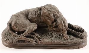statue of a dog laying down on the ground on a white background