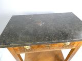 une photo d'une table au plateau en marbre posée sur un piètement en bois