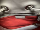 a silver purse with a red lining inside of it
