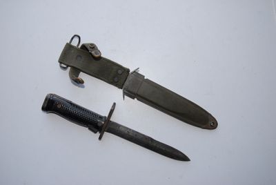 a knife and a knife holder on a white surface