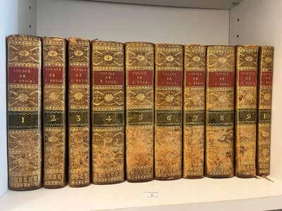 plusieurs vieux livres sont alignés sur une étagère dans une bibliothèque