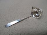 une cuillère en argent avec un manche sur une surface blanche