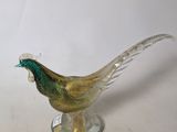 a glass bird that is sitting on a glass stand