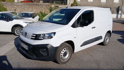 une camionnette blanche garée dans un parking à côté d'autres voitures