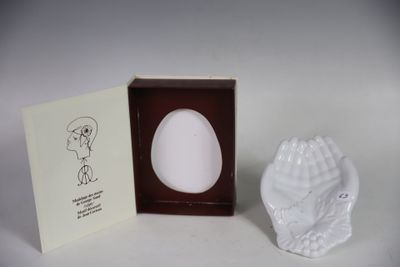 un œuf dans une boîte sur laquelle figure l'image d'une personne qui le tient