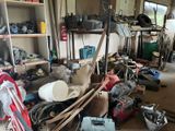 a garage with a lot of clutter and tools on the floor