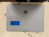 someone is holding a laptop with a blue sticker on it