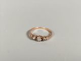 a close up of a gold ring with three diamonds on it