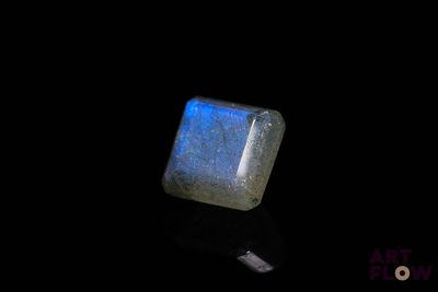 un gros plan d'une pierre bleue et blanche posée sur une surface noire