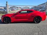 une voiture de sport rouge garée devant une clôture blanche