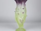 a glass vase that has a purple and green design on it