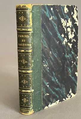 an old book sitting on top of a table next to a white table