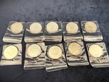 six different types of gold coins in plastic cases on a black surface