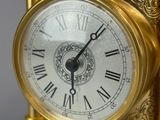 a gold clock with roman numerals on it