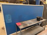 an industrial steel work bench with a blue wall behind it