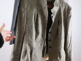 someone is holding a jacket and a jacket on a mannequin stand