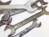 many wrenches that are laying on a white surface