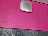 a pink table with a white speaker on top of it