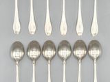 six silver spoons are arranged in a row on a gray surface