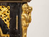 a black and gold clock with gold decorations on it