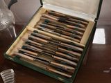 a lot of pens in a green case on a table