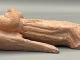 statue of a woman laying on her back on a gray surface